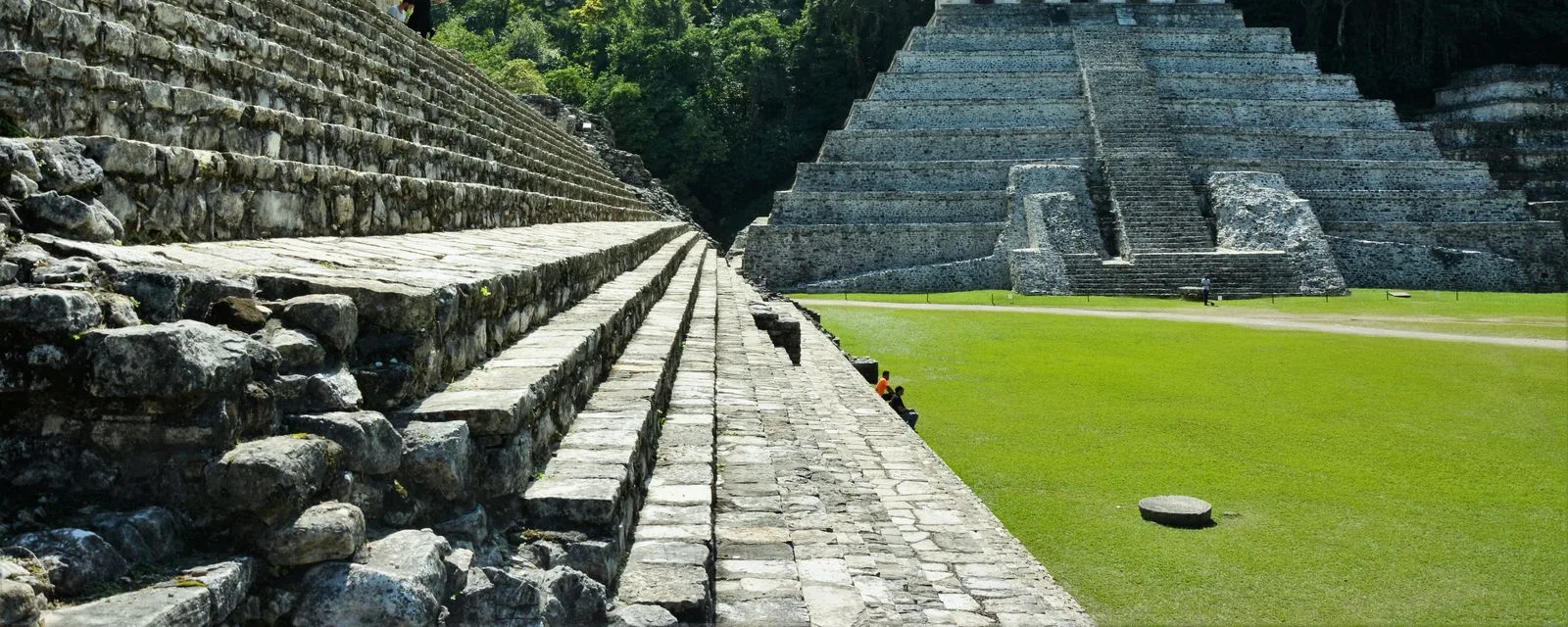 Palenque desde el costado de una plataforma: la escalinata de piedra en primer plano y el Templo de las Inscripciones al fondo, cercado por la selva