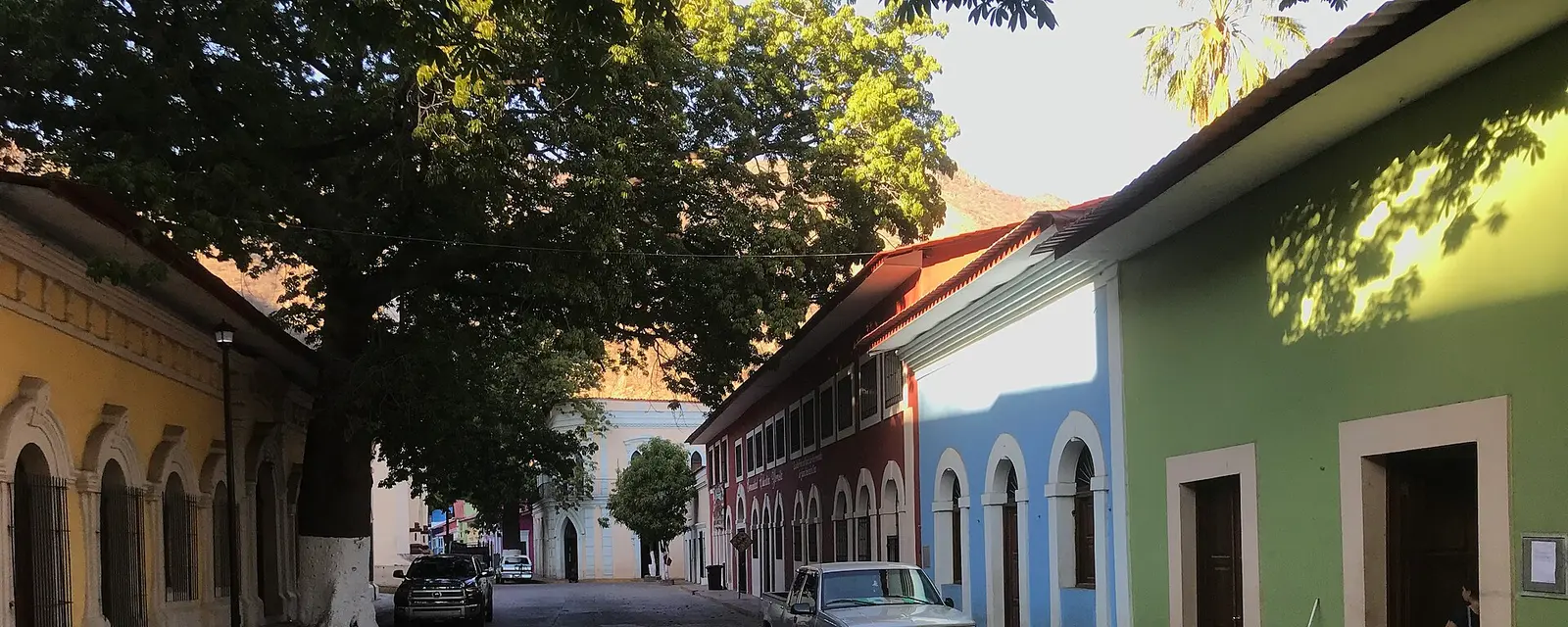 Calle empedrada con casas de colores en el fondo de la barranca de Batopilas