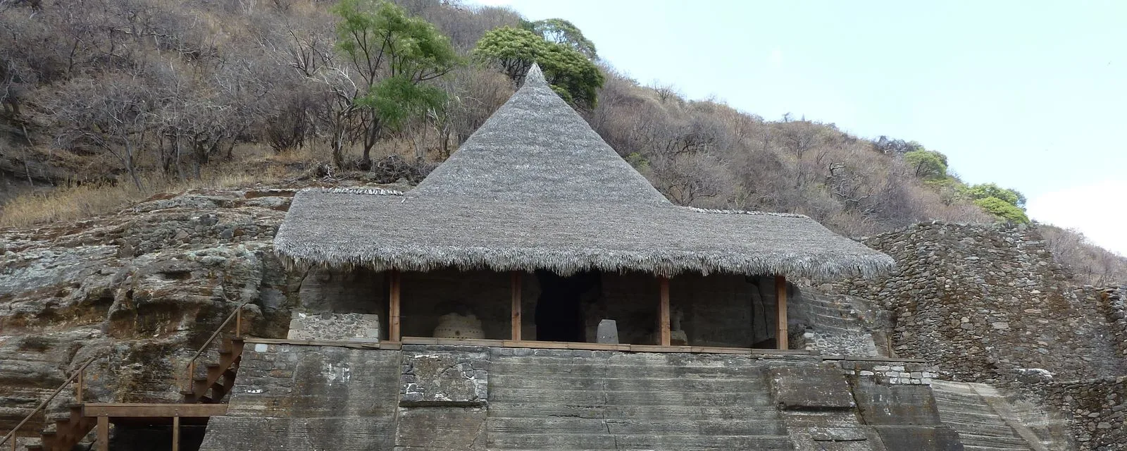 El templo monolítico Cuauhcalli de Malinalco, excavado en la roca del cerro y protegido por una techumbre cónica de palma, sobre su plataforma escalonada