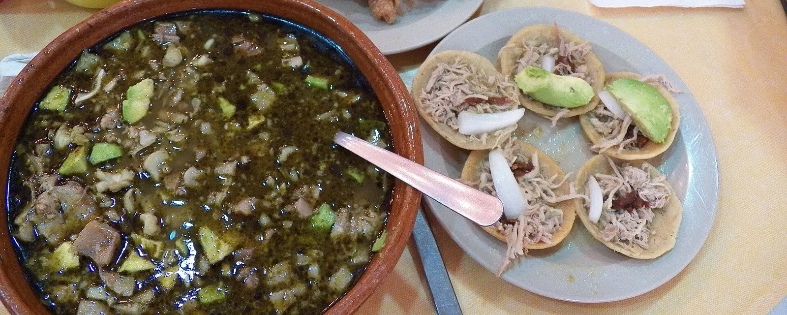 Pozole verde estilo Guerrero en cazuela de barro con tostadas, chicharrón y aguacate