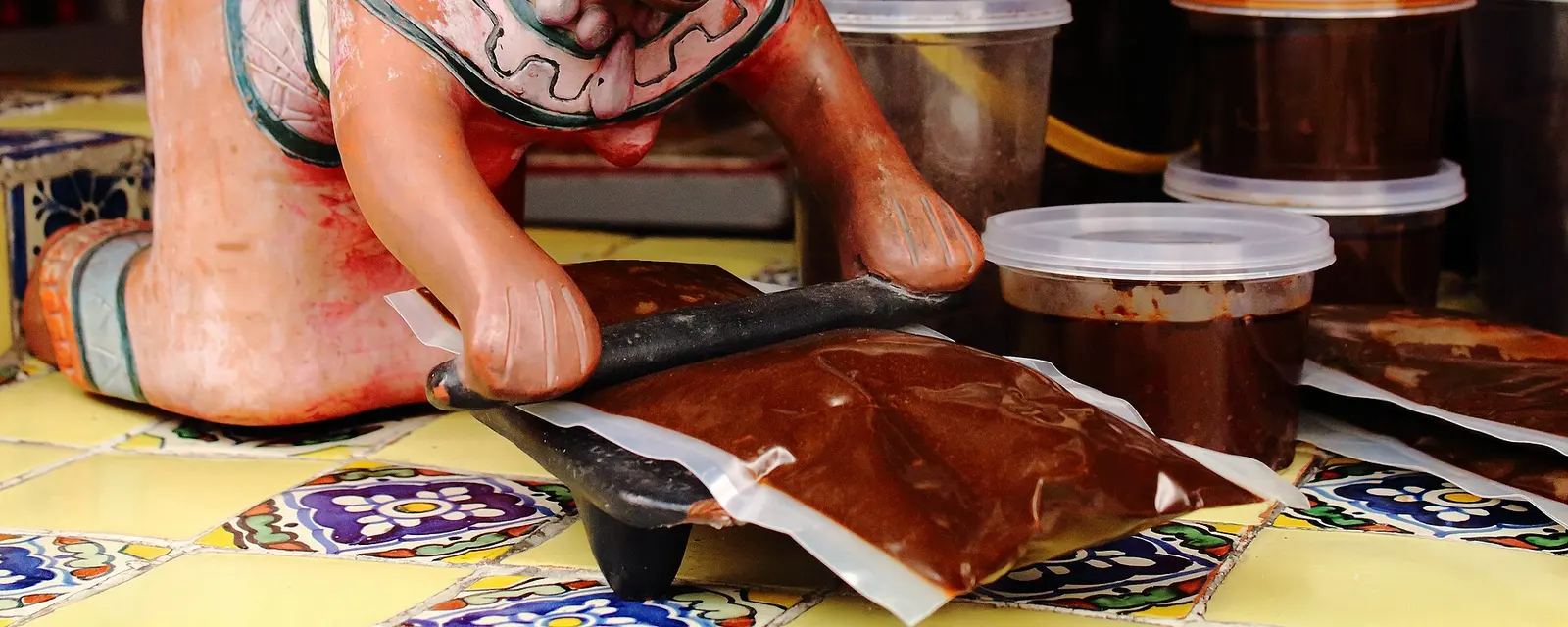 Mole poblano servido sobre pieza de pollo, bañado y espolvoreado con ajonjolí