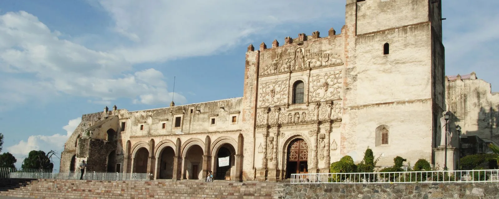 El ex convento agustino de Yuriria visto desde la explanada: su portada plateresca labrada entre la torre almenada y la arquería del pórtico