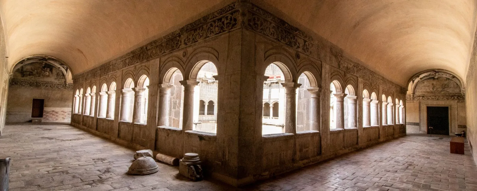 El claustro del convento de Santa María Magdalena de Cuitzeo: dos galerías abovedadas con arcos de piedra labrada sobre columnas, alrededor del patio