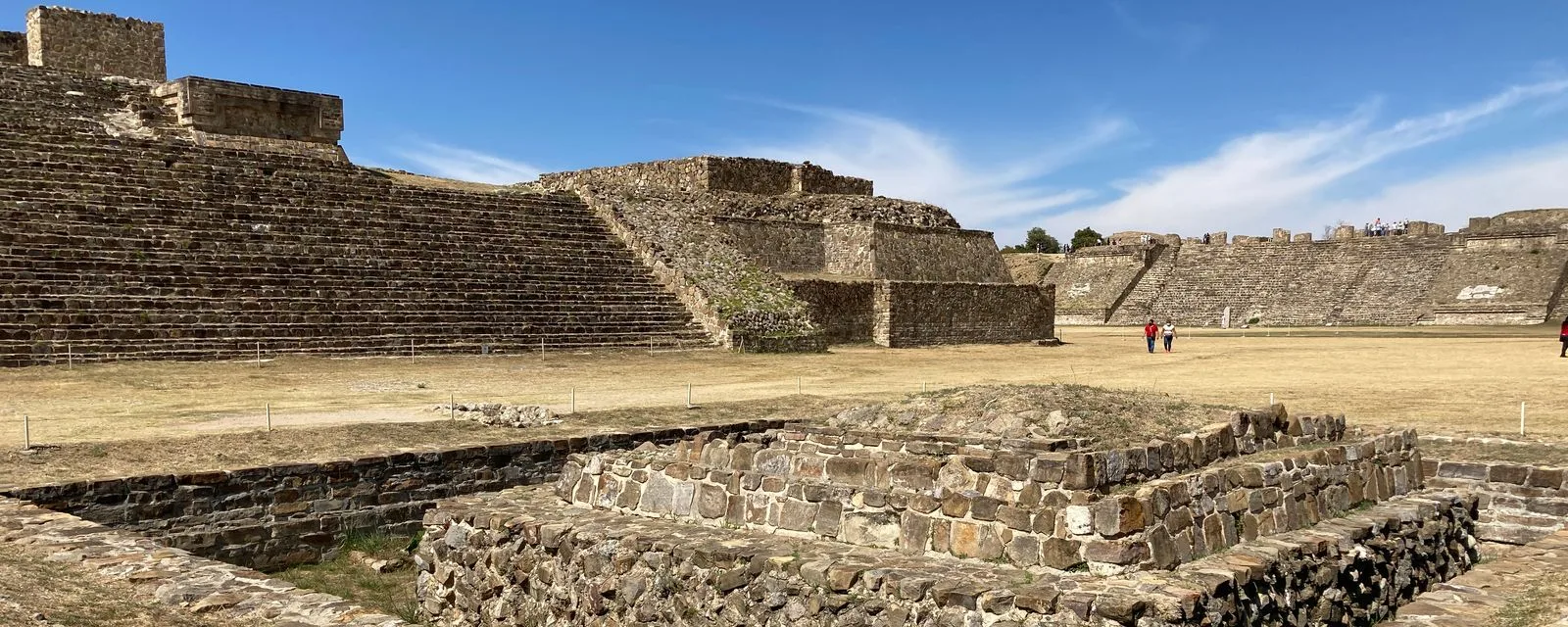 La Gran Plaza de Monte Albán: la escalinata de una plataforma a la izquierda y los basamentos de piedra recortados contra el cielo del valle