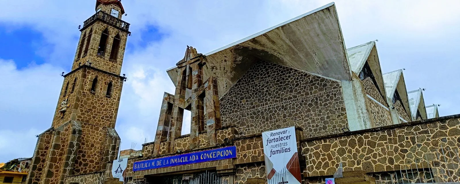 La basílica de la Inmaculada Concepción de Chignahuapan: la torre de piedra del campanario junto a la nave moderna de muros de mampostería