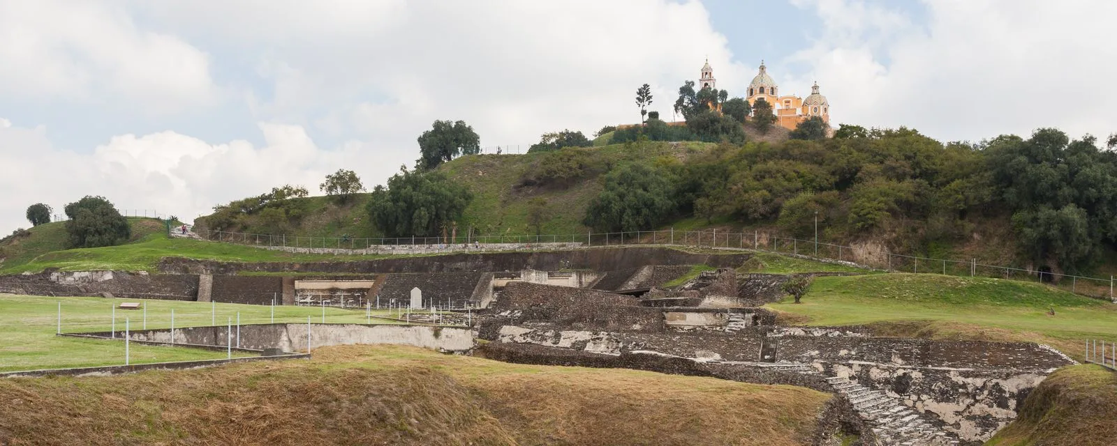 La Gran Pirámide de Cholula: las estructuras excavadas al pie del cerro y, arriba de todo, el Santuario de los Remedios coronando el montículo