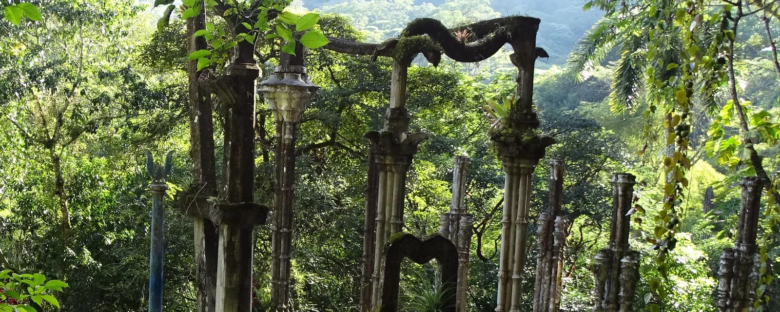 Columnas y un arco serpenteante de concreto del jardín surrealista de Las Pozas, en Xilitla, cubiertos de musgo y rodeados por la selva