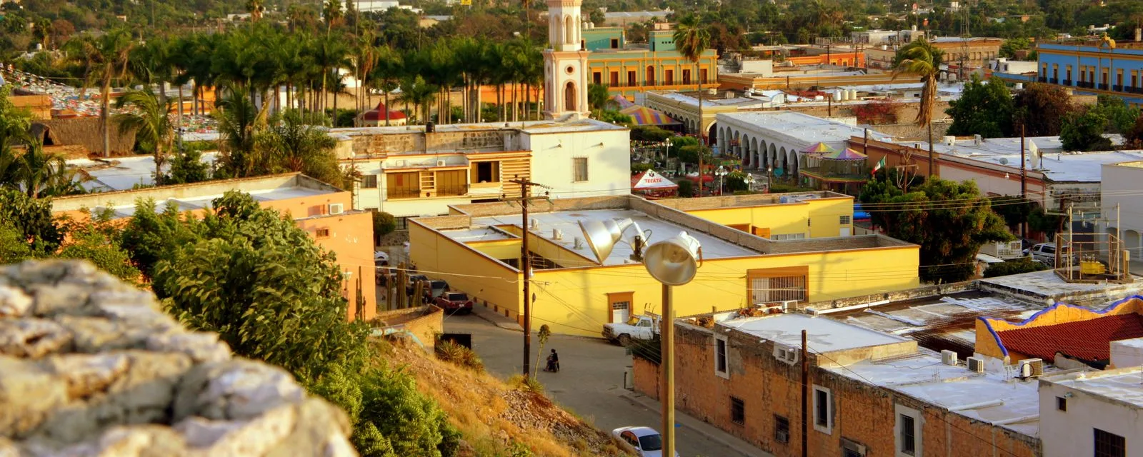 El Fuerte visto desde la muralla del fuerte: los techos del pueblo, las palmas de la plaza y la torre de la iglesia con la luz de la tarde