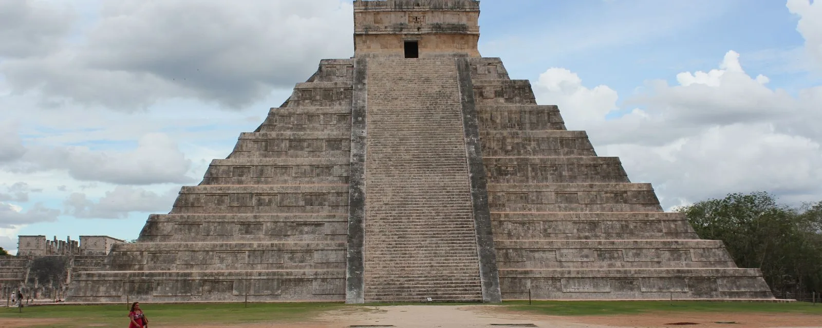 El Castillo de Chichén Itzá de frente: la escalinata central subiendo recta hasta el templo de la cima, con el Templo de los Guerreros a la izquierda