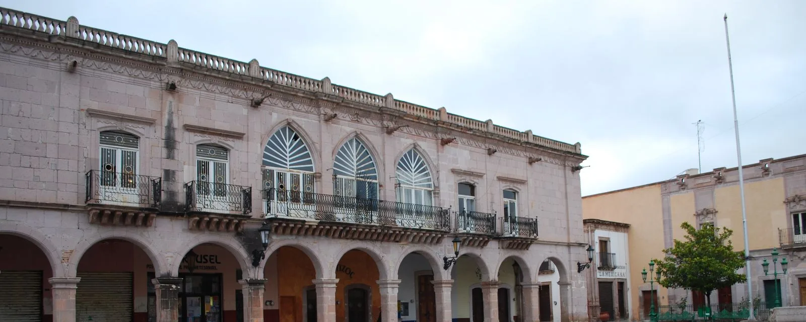 Los Portales de las Palomas en Jerez: la arquería de cantera en planta baja y los ventanales ojivales con balcones de herrería en el piso alto